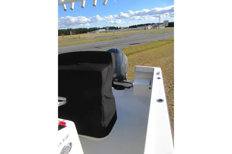 Slide: The Image of 2022 Parker 2300 Special Edition boat with covered engine, parked near a road under a blue sky. - 10