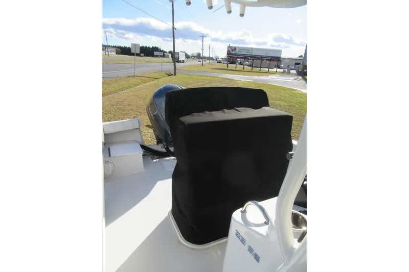 Slide: The Image of 2022 Parker 2300 Special Edition boat with covered engine, parked near a road. - 11