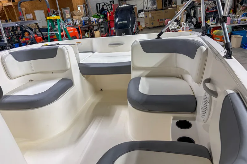 Slide: The Image of 2020 Bayliner Element E16 boat interior with gray and white seating in a workshop. - 6