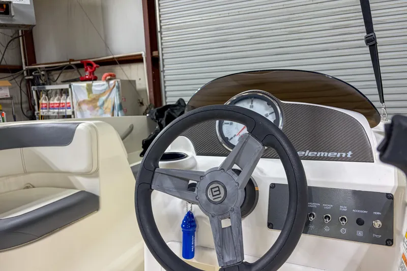 Slide: The Image of 2020 Bayliner Element E16 boat dashboard with steering wheel and control panel. - 9