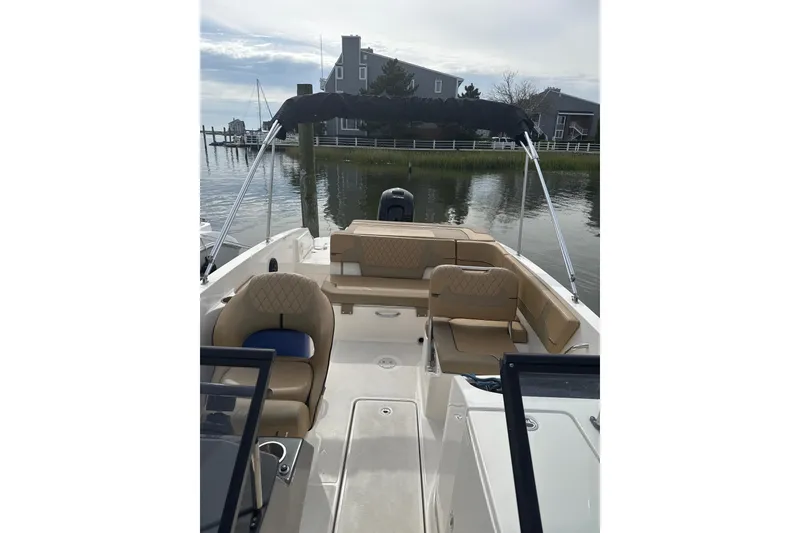Slide: The Image of 2025 Bayliner VR6 Bowrider OB with tan seating, docked near waterfront homes. - 2