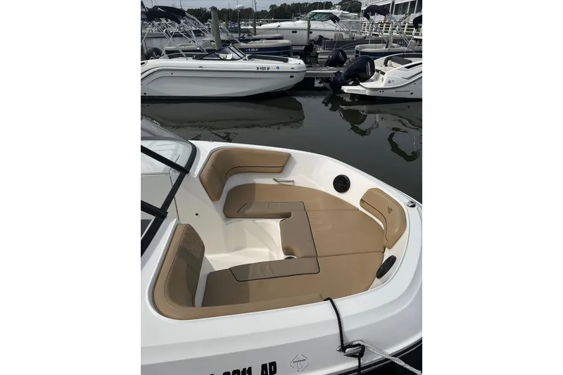 Slide: The Image of 2025 Bayliner VR6 Bowrider OB with tan seating, docked in a marina. - 5