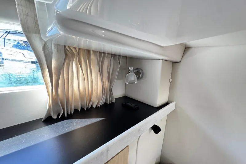 Slide: The Image of Interior of 2026 Regal 33 XO yacht with elegant curtains and sleek countertop design. - 122