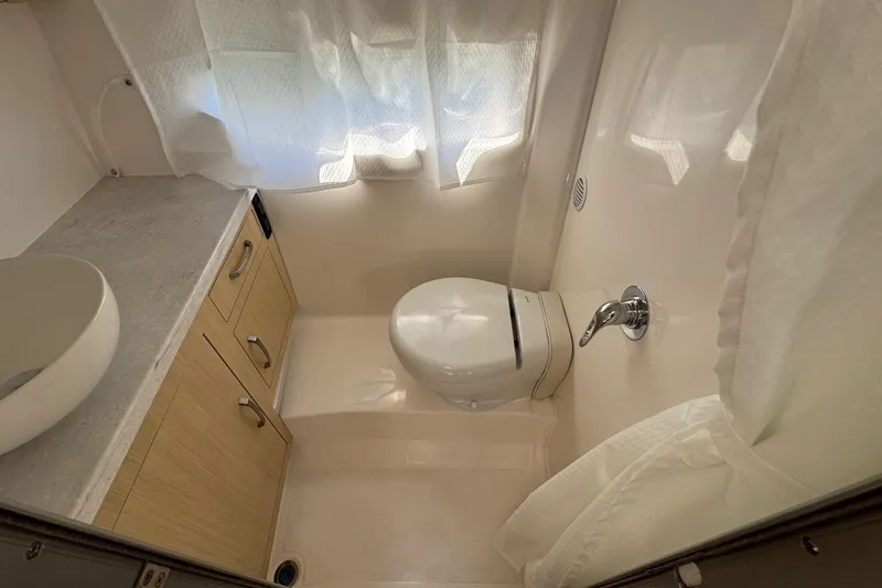Slide: The Image of 2026 Regal 33 XO boat bathroom with modern fixtures and light wood cabinetry. - 126