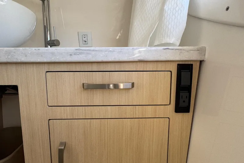 Slide: The Image of 2026 Regal 33 XO yacht bathroom with wooden cabinet and marble countertop. - 132