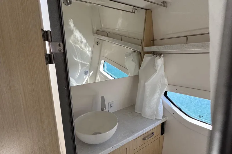 Slide: The Image of 2026 Regal 33 XO yacht bathroom with modern sink, mirror, and window view. - 136