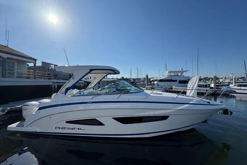 Slide: The Image of 2026 Regal 33 XO boat docked at marina under clear blue sky. - 3