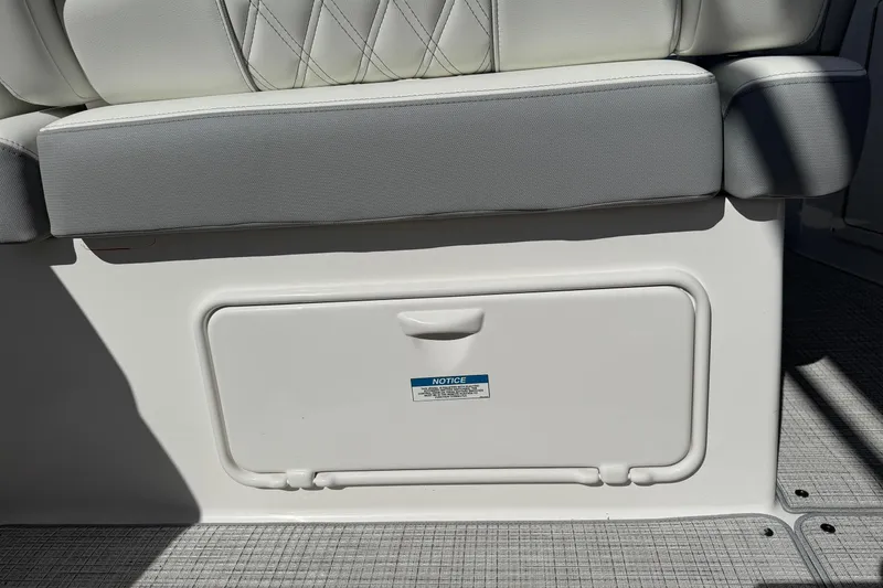 Slide: The Image of 2026 Regal 33 XO boat seat with storage compartment, featuring white and gray upholstery. - 38