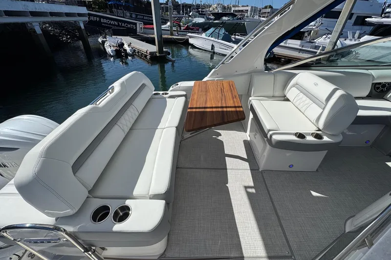 Slide: The Image of 2026 Regal 33 XO yacht interior with white seating and wooden table. - 42