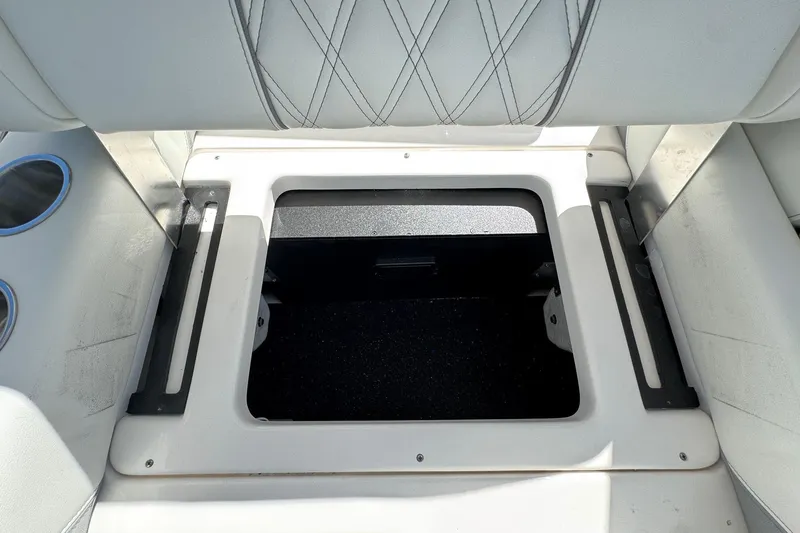 Slide: The Image of 2026 Regal 33 XO boat storage compartment with cushioned seating and cup holders. - 47
