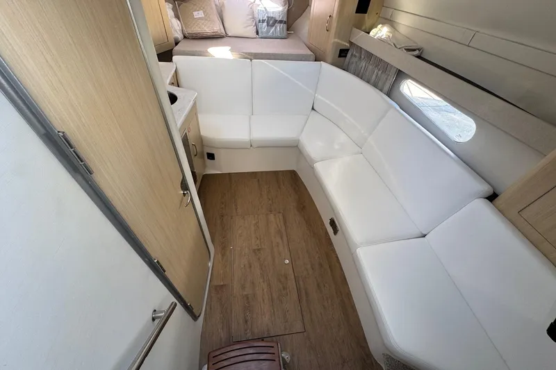 Slide: The Image of 2026 Regal 33 XO yacht interior with white seating and wood flooring. - 74