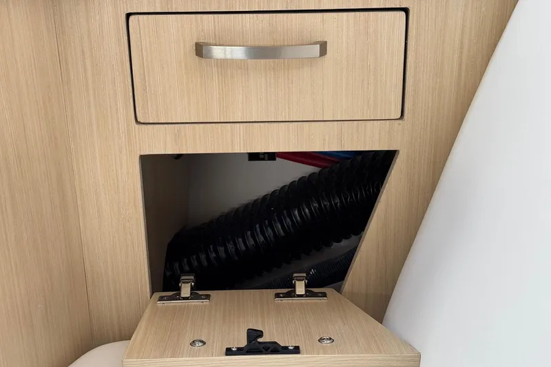 Slide: The Image of 2026 Regal 33 XO interior storage compartment with open hatch and visible wiring. - 86