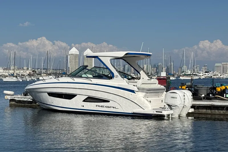 Slide: The Image of 2026 Regal 33 XO boat docked in marina with city skyline background. - 9