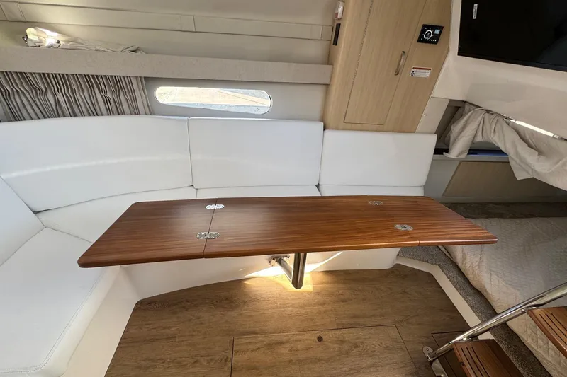 Slide: The Image of Interior of 2026 Regal 33 XO yacht with wooden table and white seating. - 99