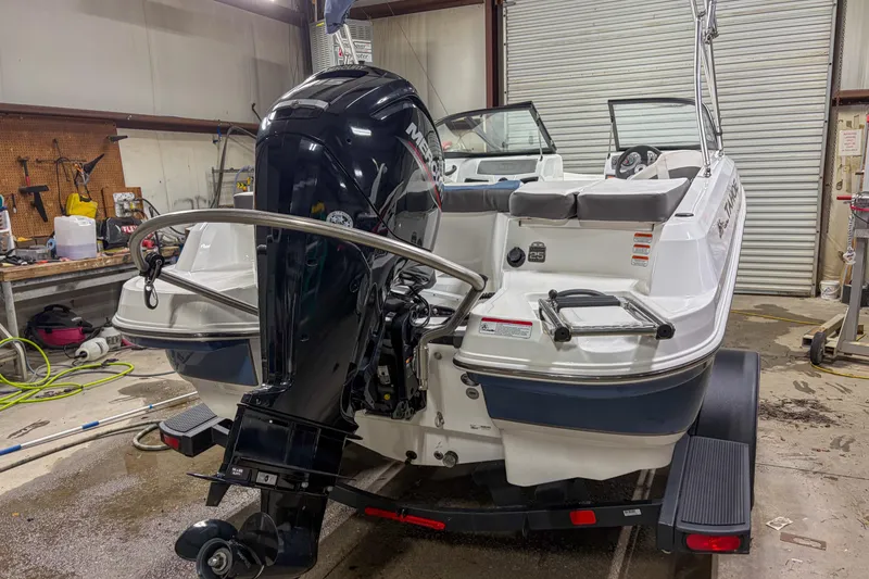 Slide: The Image of 2023 Tahoe 185 S boat in a workshop, featuring a powerful outboard motor. - 10