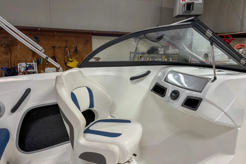 Slide: The Image of 2023 Tahoe 185 S boat interior with white and blue seating, dashboard, and windshield. - 8