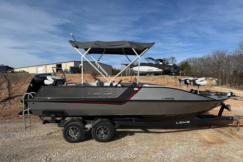 Slide: The Image of 2026 Lowe Sport Deck 224 boat on trailer, featuring sleek design and canopy. - 4
