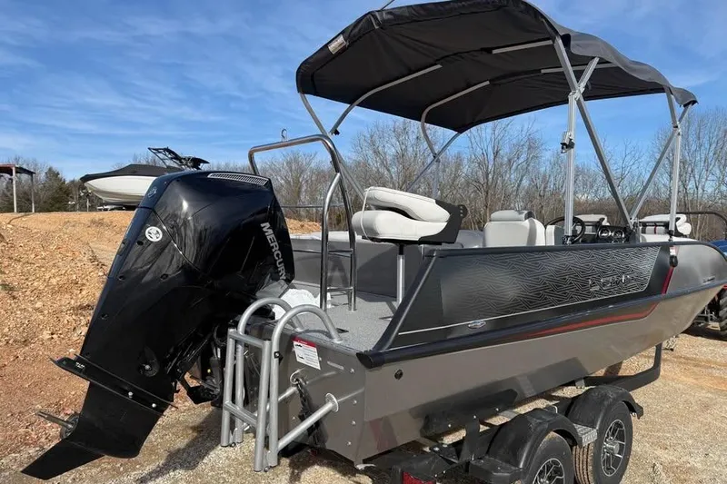 Slide: The Image of 2026 Lowe Sport Deck 224 boat with Mercury outboard motor and canopy, parked on trailer. - 5
