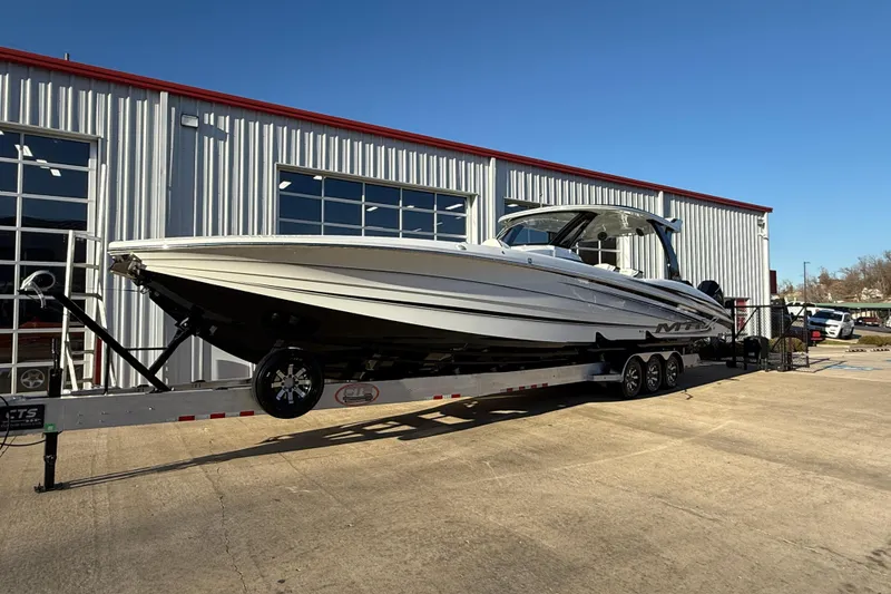 Slide: The Image of 2021 MTI 42V boat on trailer outside a metal building under clear blue sky. - 3