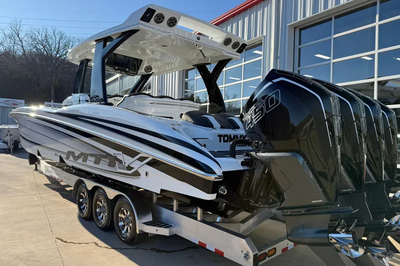 Slide: The Image of 2021 MTI 42V boat with powerful engines on a trailer outside a modern building. - 4