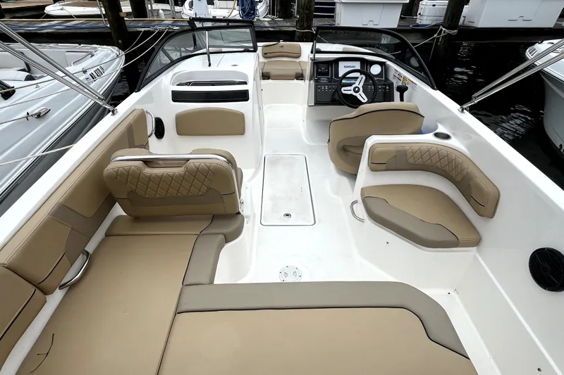 Slide: The Image of 2025 Bayliner VR6 Bowrider OB interior with tan seating and modern dashboard. - 7