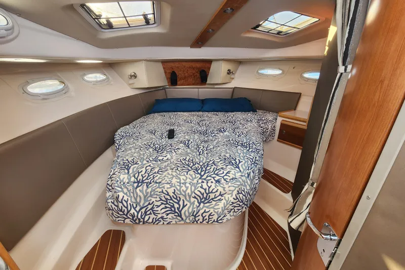 Slide: The Image of 2021 Cutwater C-32 CB cabin interior with bed, skylights, and wood accents. - 18