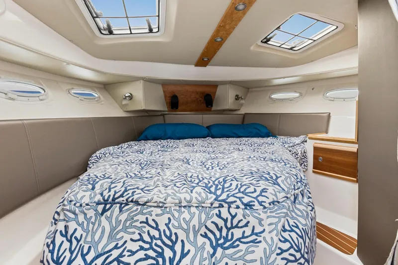 Slide: The Image of 2021 Cutwater C-32 CB cabin interior with bed and nautical decor. - 21