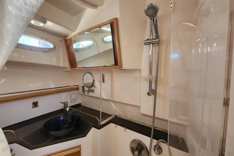 Slide: The Image of 2021 Cutwater C-32 CB yacht bathroom with modern fixtures and porthole windows. - 24