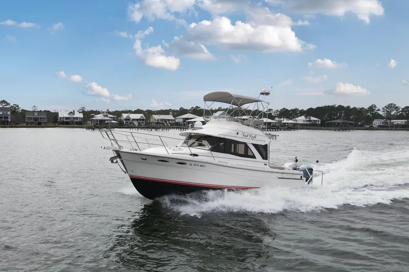 Slide: The Image of 2021 Cutwater C-32 CB cruising on a lake with houses in the background. - 3