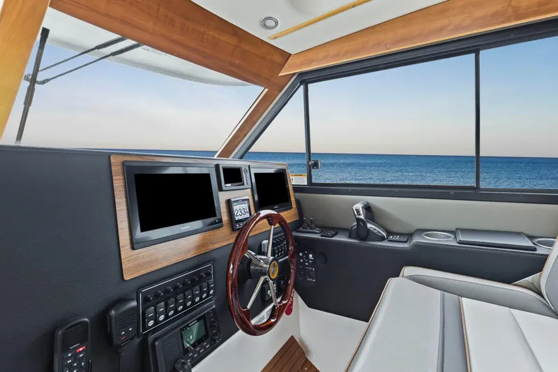 Slide: The Image of 2021 Cutwater C-32 CB helm with modern controls, overlooking the ocean through large windows. - 30
