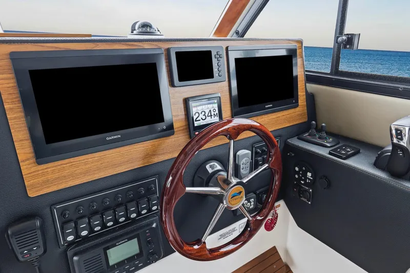 Slide: The Image of 2021 Cutwater C-32 CB helm with Garmin displays and wooden steering wheel. - 32
