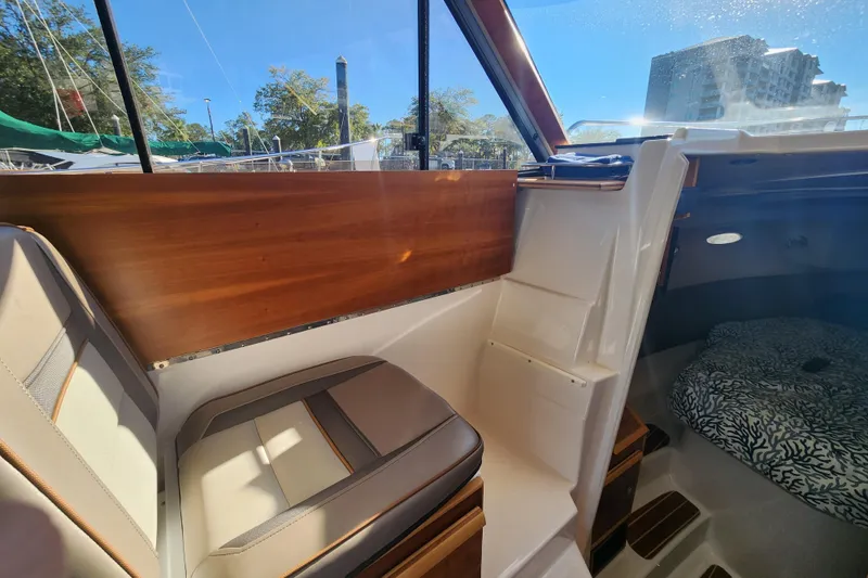 Slide: The Image of 2021 Cutwater C-32 CB interior with seating and cabin view, featuring wood accents. - 35