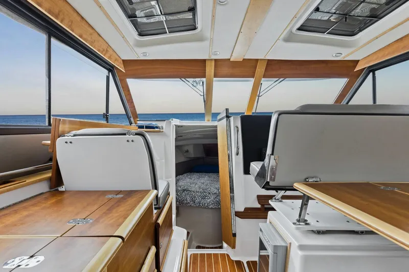 Slide: The Image of Interior of 2021 Cutwater C-32 CB boat with wood accents and ocean view. - 38