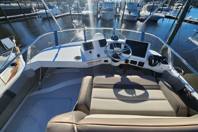 Slide: The Image of 2021 Cutwater C-32 CB boat helm with modern controls and marina view. - 42