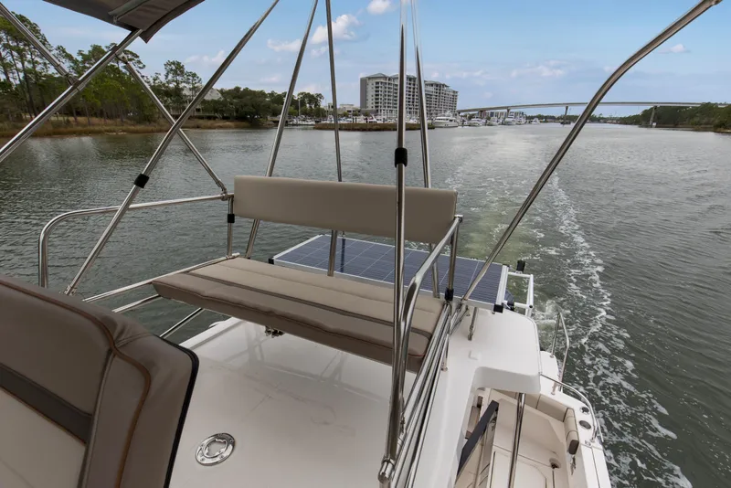 Slide: The Image of 2021 Cutwater C-32 CB boat cruising on a scenic waterway with solar panels. - 48