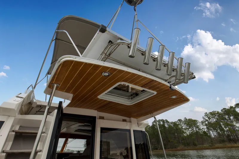 Slide: The Image of 2021 Cutwater C-32 CB boat with upper deck and rod holders against blue sky. - 49