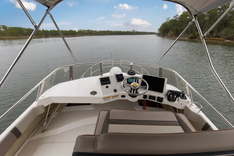 Slide: The Image of 2021 Cutwater C-32 CB boat helm with scenic waterway view. - 50
