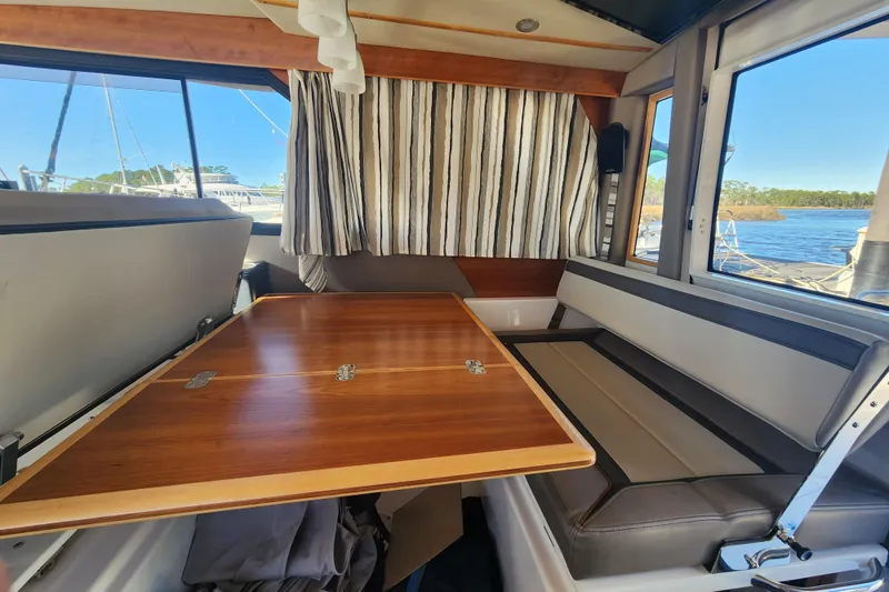 Slide: The Image of Interior of 2021 Cutwater C-32 CB boat with wooden table and seating area. - 74