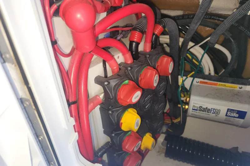 Slide: The Image of Electrical system of a 2021 Cutwater C-32 CB boat with red cables and switches. - 79