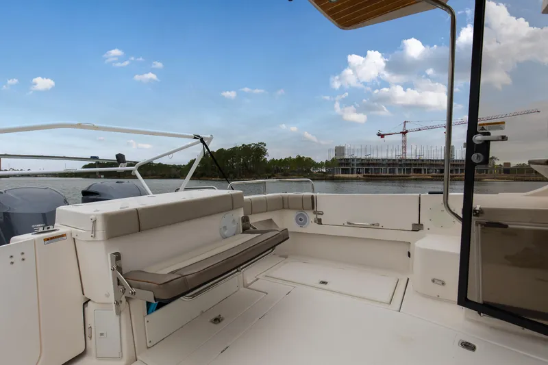 Slide: The Image of 2021 Cutwater C-32 CB boat interior with seating, overlooking waterfront construction. - 8