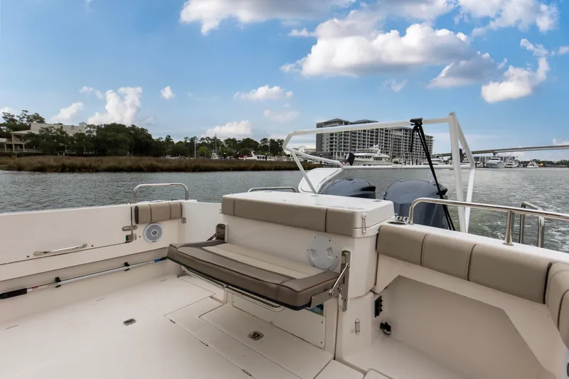 Slide: The Image of 2021 Cutwater C-32 CB boat deck with seating, overlooking marina and buildings. - 9