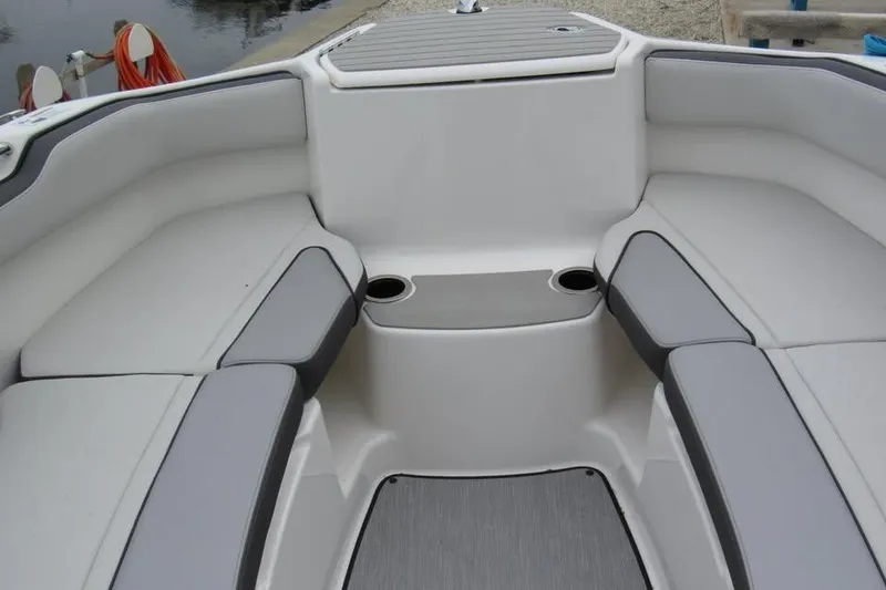 Slide: The Image of 2025 Yamaha Boats AR250 interior seating with cup holders and sleek design. - 8