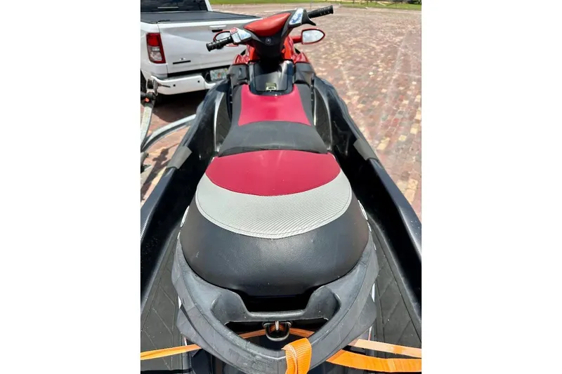 Slide: The Image of 2006 Sea-Doo RXT jet ski with red and black seat, parked on a trailer. - 8