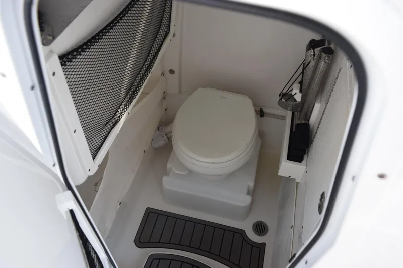 Slide: The Image of 2021 Sea Hunt Ultra 255 SE boat interior with compact marine toilet. - 18