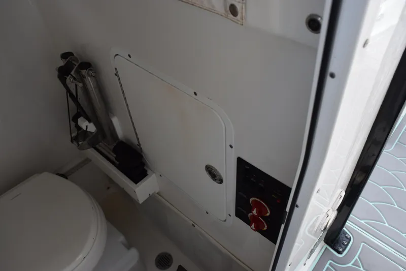 Slide: The Image of Interior of 2021 Sea Hunt Ultra 255 SE boat, featuring a compact bathroom area. - 19
