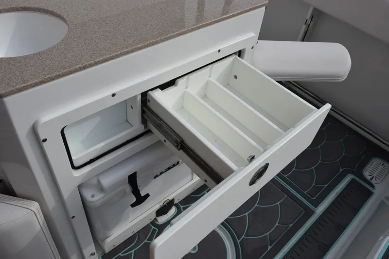 Slide: The Image of 2021 Sea Hunt Ultra 255 SE boat storage compartment with open drawer and cooler. - 28