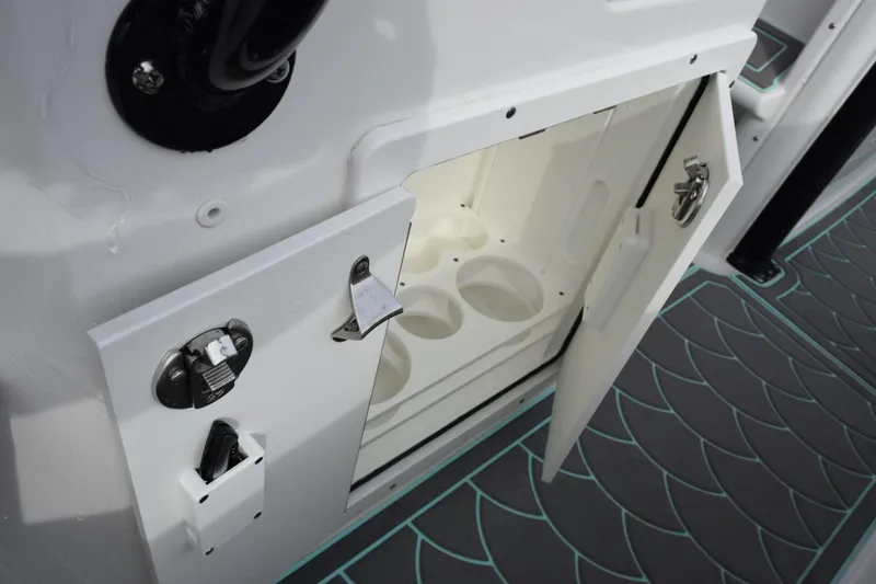 Slide: The Image of 2021 Sea Hunt Ultra 255 SE boat storage compartment with cup holders and secure latch. - 31