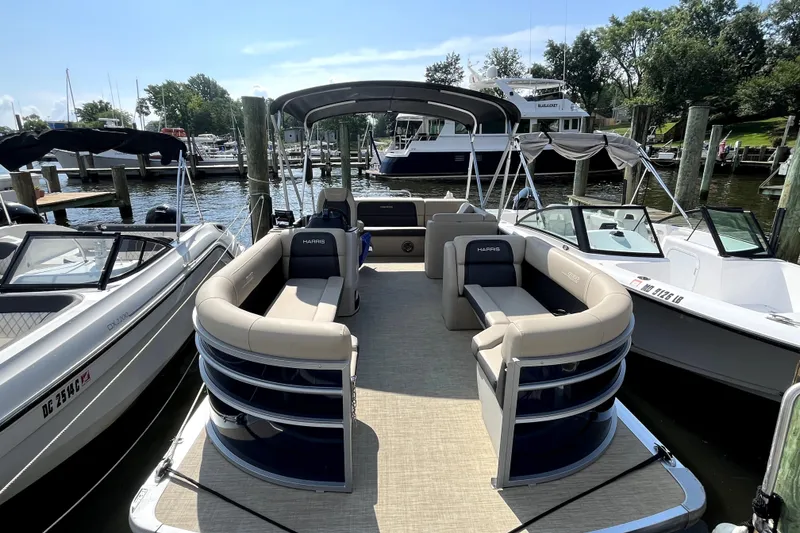 Slide: The Image of Pontoon boat Harris HCX23, 2025 model, docked at marina with other boats. - 3