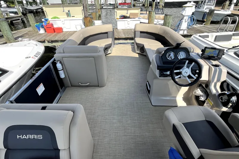 Slide: The Image of Interior of a 2025 Harris HCX23 boat with modern seating and steering console. - 5