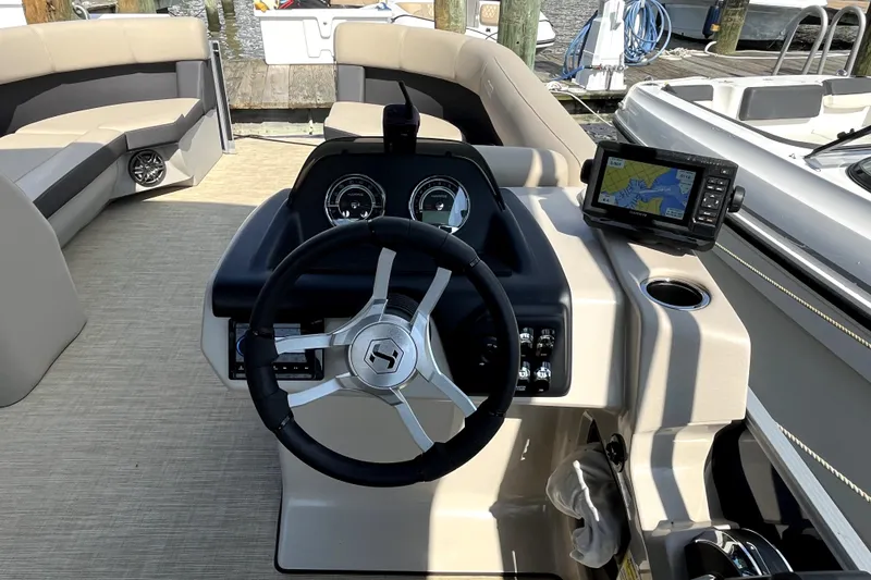 Slide: The Image of Steering console of 2025 Harris HCX23 boat with navigation system and seating area. - 6